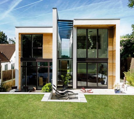 Modern minimalist home with wooden and glass facade, spacious interior and outdoor living area.
