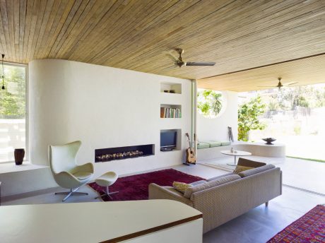 Spacious living room with wood-paneled ceiling, fireplace, and modern furniture.
