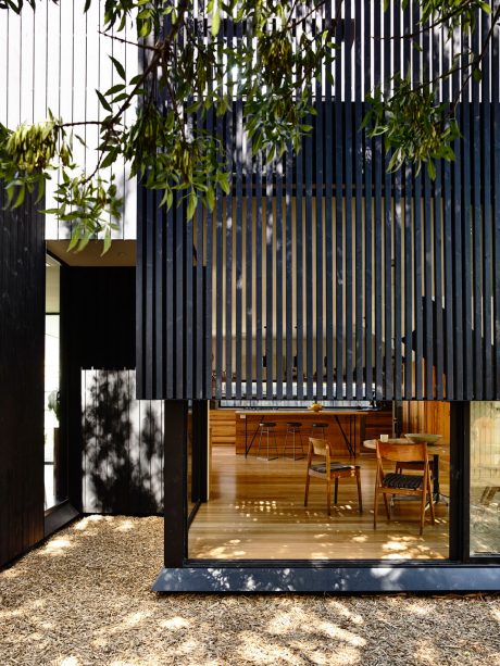 Minimalist wooden and steel structure with expansive glazing and natural interiors.