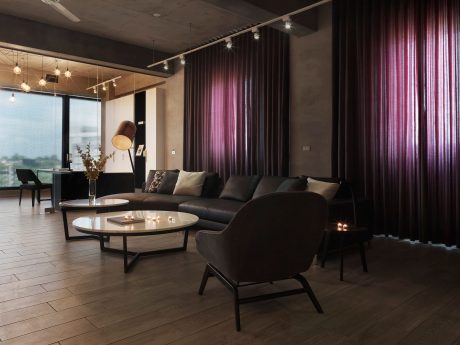 Intimate lounge with plush seating, modern lighting, and dramatic curtains creating a cozy ambiance.