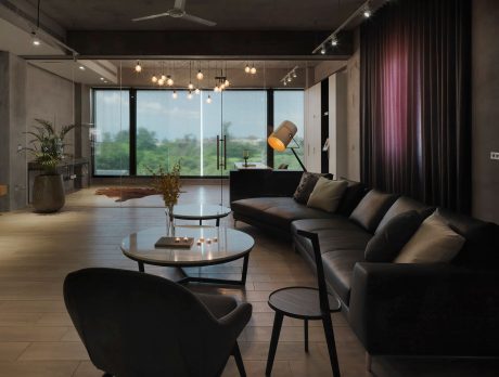 Sleek, modern living room with plush leather sofas, minimalist furnishings, and pendant lighting.