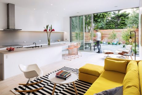 Bright, modern living space with sleek kitchen, colorful furnishings, and expansive outdoor views.