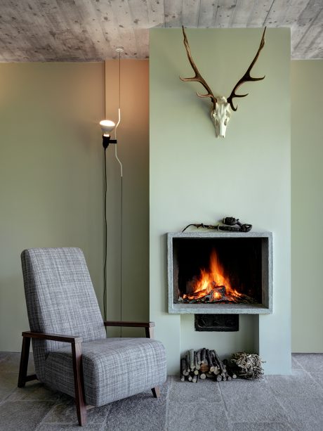 Cozy living room with a fireplace, rustic decor, and a comfortable armchair.