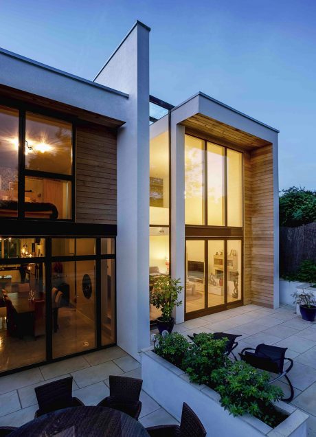 Contemporary home with clean lines, large windows, wood accents, and landscaped patio.