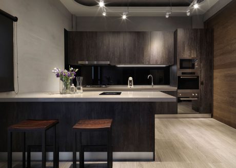 Sleek and modern kitchen with dark wood cabinets, minimalist design, and pendant lighting.