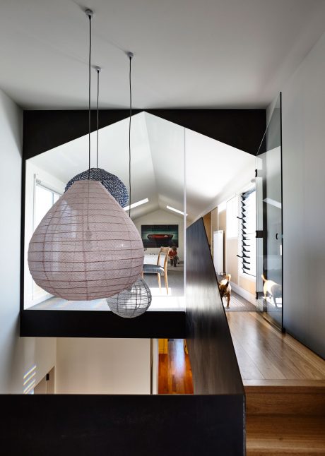 A modern, minimalist interior with suspended spherical light fixtures and contrasting black and white walls.