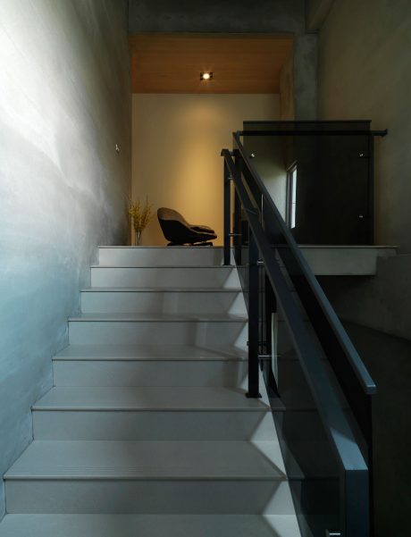 Sleek modern staircase design with contrasting materials and subdued lighting.