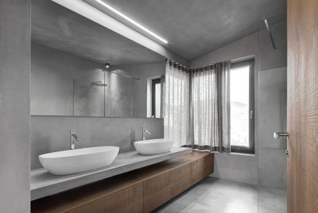 Sleek, minimalist bathroom with concrete walls, floating vanity, and modern fittings.