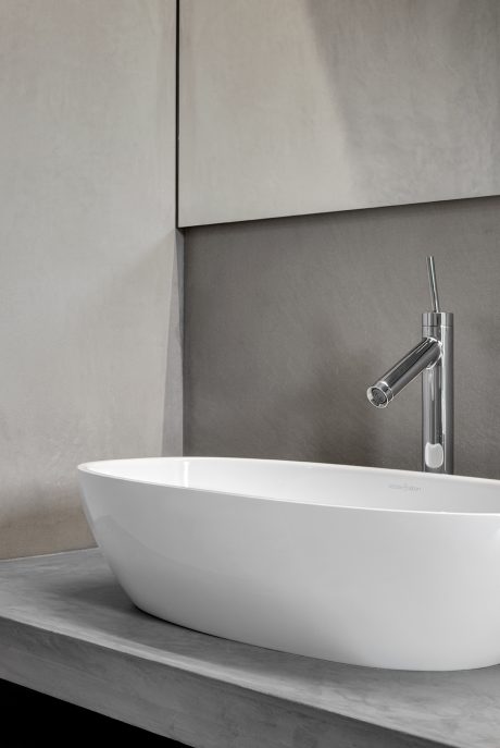 Modern bathroom with sleek white bathtub, chrome faucet, and minimalist wall decor.