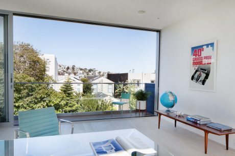 Airy living room with large windows offering scenic city views, minimalist furniture, and decor.