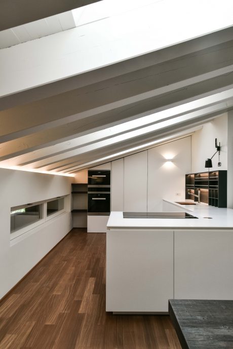 Well-designed modern kitchen with sleek cabinets, wood flooring, and recessed lighting.