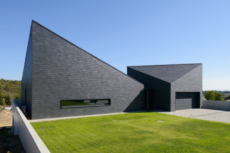 Striking modern architecture with dramatic black slate exterior and geometric shapes.