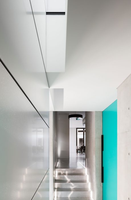 Minimalistic architectural interior with clean lines, recessed lighting, and a hint of turquoise.
