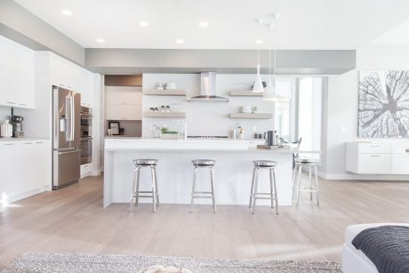Modern kitchen with sleek white cabinetry, open shelving, and stainless steel appliances.