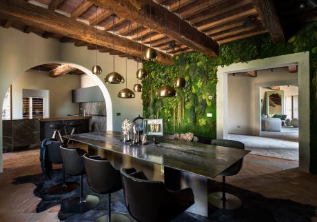 Rustic wooden beams, sleek modern furnishings, and a stunning moss-covered feature wall create a stunning interior space.