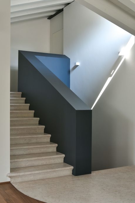 A modern staircase with geometric patterns and contrasting colors in an interior space.