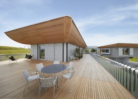 Sleek wooden pavilion with geometric mosaic facade, elevated deck, and modern outdoor furnishings.