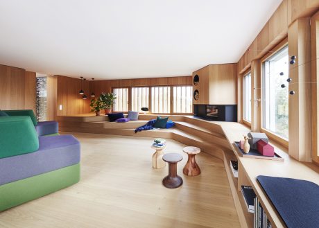 Spacious room with wooden paneling, built-in seating, and natural light through large windows.