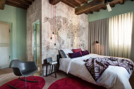 A modern bedroom with rustic beams, textured walls, and pendant lighting creating a cozy ambiance.