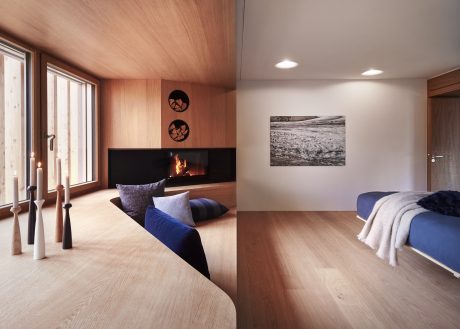 Modern bedroom with wooden accents, fireplace, and abstract art on the walls.