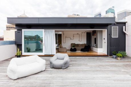 Sleek, modern rooftop terrace with minimalist furniture and open indoor-outdoor layout.