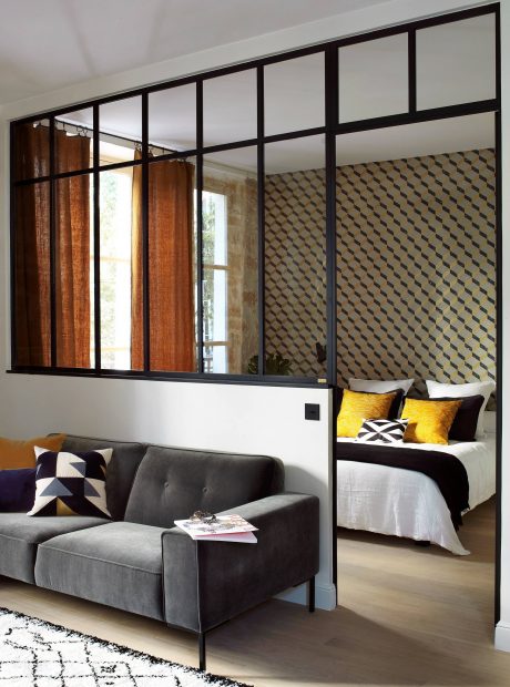 Stylish interior with minimalist metal frame windows, geometric wallpaper, and contrasting gray and yellow accents.