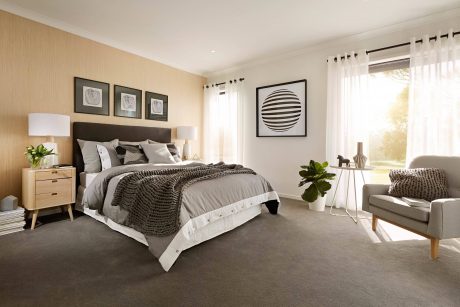 Warm, modern bedroom with neutral colors, geometric artwork, and midcentury-style furnishings.