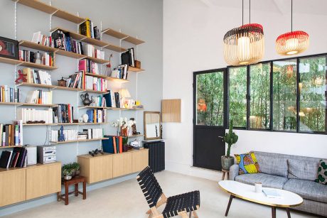 Cozy and well-designed living room with floor-to-ceiling windows, bookshelves, and modern lighting.