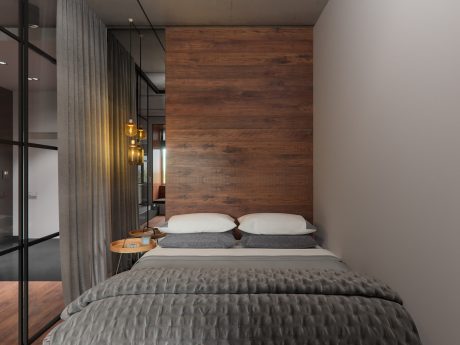 Cozy modern bedroom with wood paneling, soft lighting, and minimalist decor.