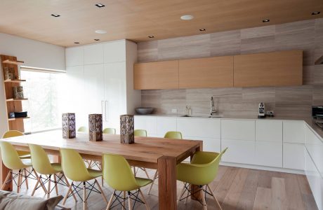Modern, open-concept kitchen and dining area with wood, white, and yellow accents.