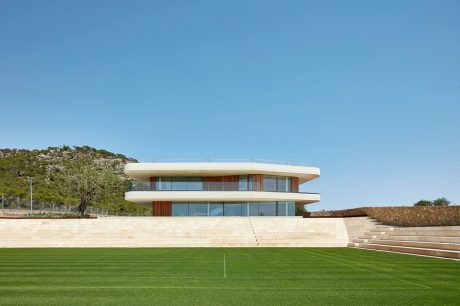 Modern two-story building with clean lines, large windows, and wood accent panels.