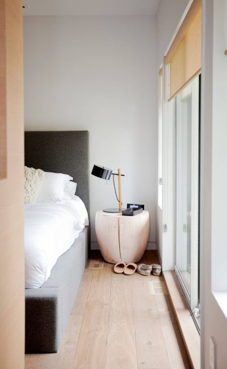 Cozy bedroom with minimalist decor, neutral tones, and wooden flooring.