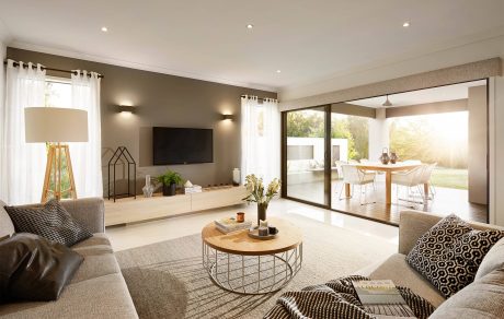Spacious, modern living room with neutral tones, sleek furniture, and large sliding glass doors leading to an outdoor area.