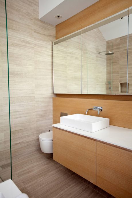 Contemporary bathroom with sleek wooden vanity, vessel sink, and recessed mirror cabinet.