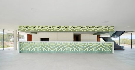 Spacious interior featuring green tiled walls and a minimalist open layout.