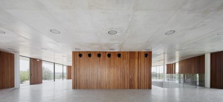 Spacious, minimalist interior with wood paneling, recessed lighting, and expansive windows.