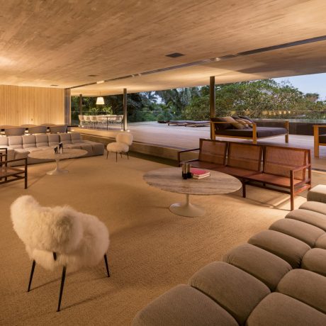 Spacious, open-concept living area with wood-paneled ceiling, plush seating, and outdoor view.