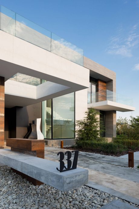 Sleek, modern architectural design with clean lines, glass, and stone accents.