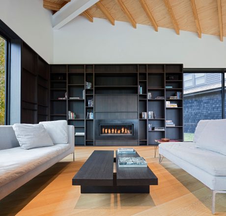 A modern, cozy living room with a sleek fireplace surrounded by custom built-in shelving.
