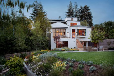 Contemporary two-story home with extensive landscaping, large windows, and sleek architectural features.