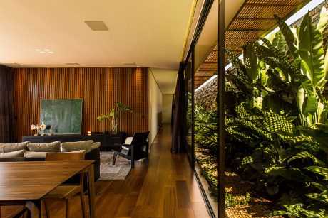 Stunning wooden interior with lush tropical foliage visible through glass walls.