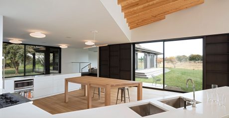Spacious, airy modern interior with wooden beams, large windows, and minimalist design.