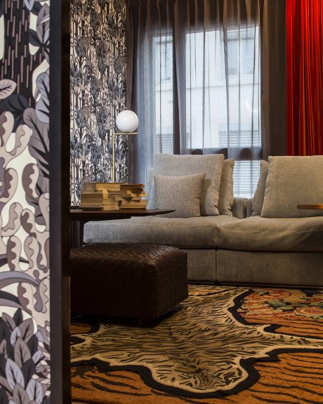 Chic living room with patterned curtains, plush sofa, and bold tiger-print rug.