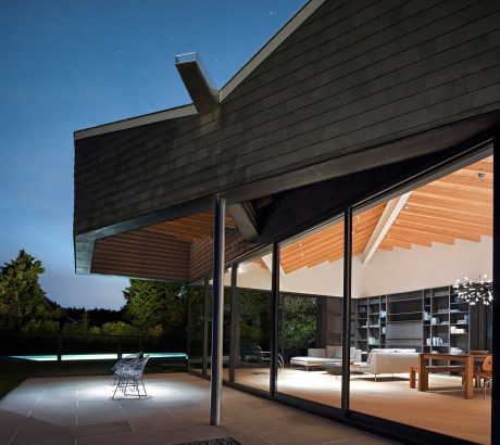 Sleek modern architecture with wooden beams, large glass windows, and minimalist interior.