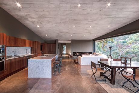 Spacious modern kitchen with sleek wood cabinetry, granite countertops, and large windows providing scenic views.