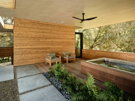 Cozy wooden patio with soothing water feature, natural foliage, and relaxing seating.
