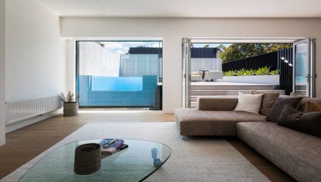Sleek, modern living space with large windows, pool, and stylish furnishings.