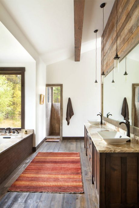 Rustic bathroom with wooden beams, vessel sinks, and a striped rug on the floor.
