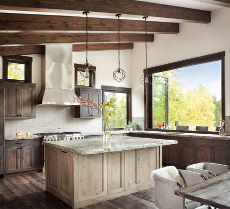 Rustic kitchen with exposed wood beams, pendant lights, and a large granite-topped island.