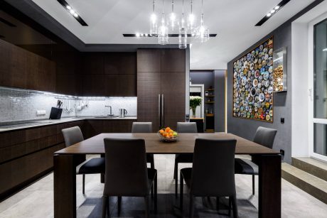 Sleek, modern kitchen with dark wood cabinetry, glass backsplash, and a colorful wall art piece.
